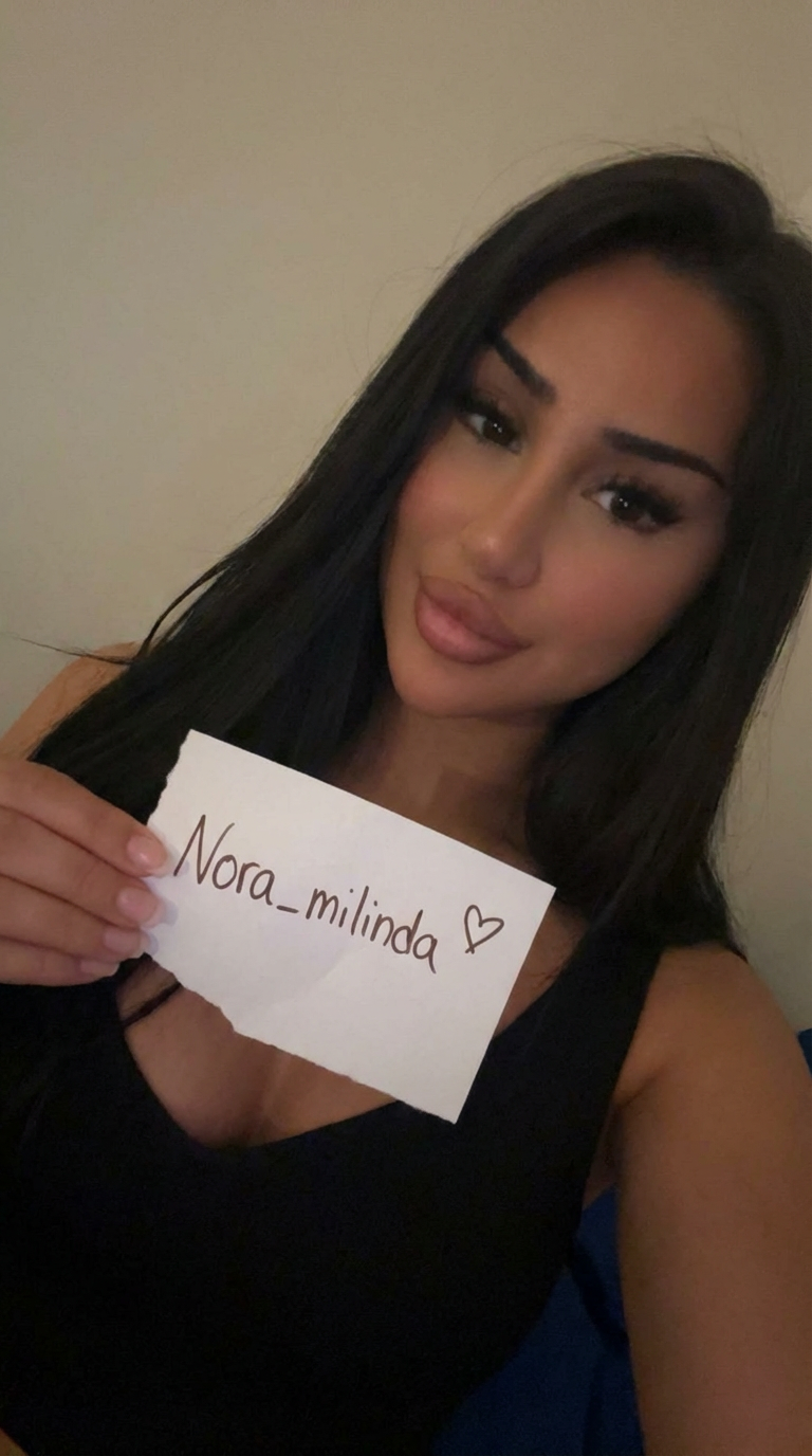 AI generated image using NANO_BANANA_PRO: She should be holding a note that says Nora_milinda with a small heart on it. Pl...